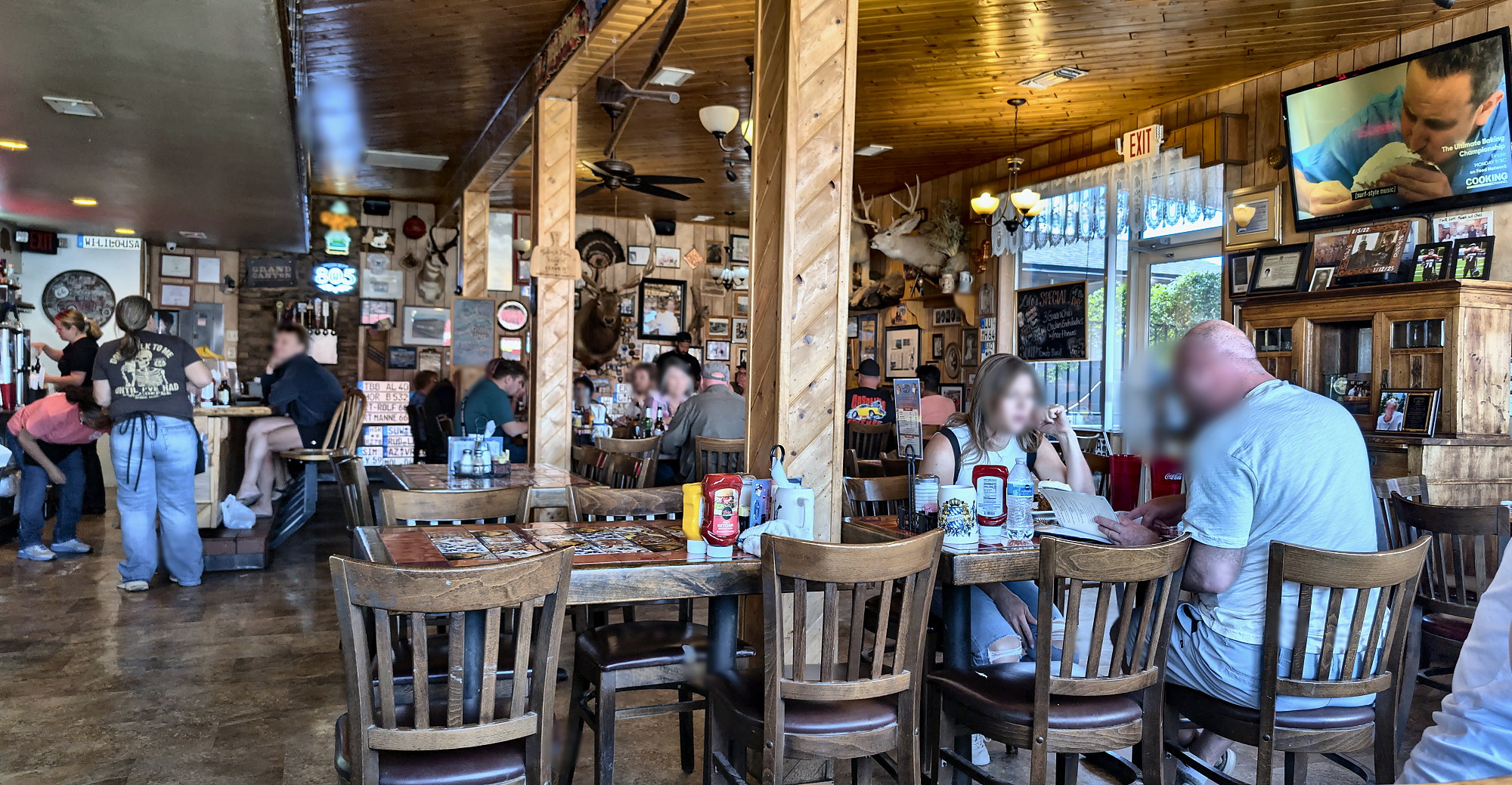 Inside Lilo's: wood-paneled walls and ceiling, wooden tables and chairs, a few diners at lunch